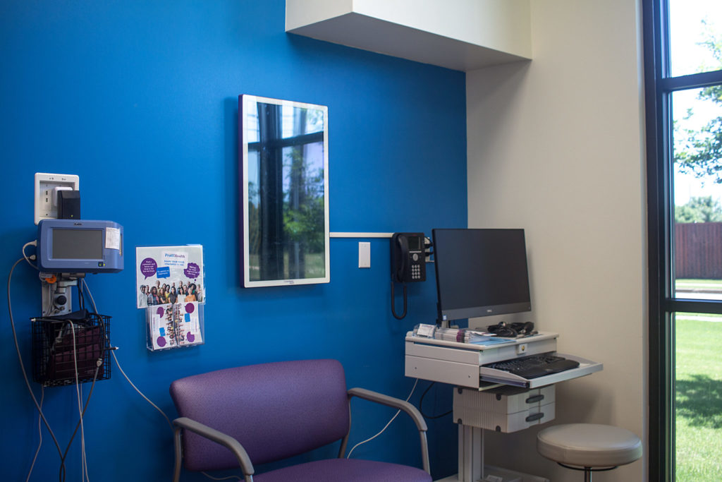 Exam room with blue wall and floor to ceiling window