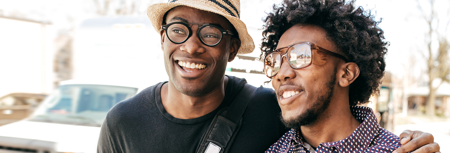 black male gay couple walking down the street smiling