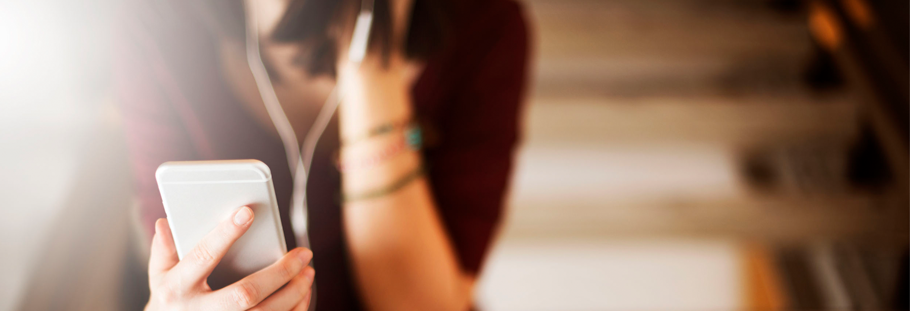 Woman listening to audio on mobile phone through headsets