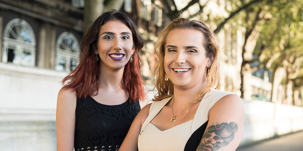 Two transgender females smiling outside