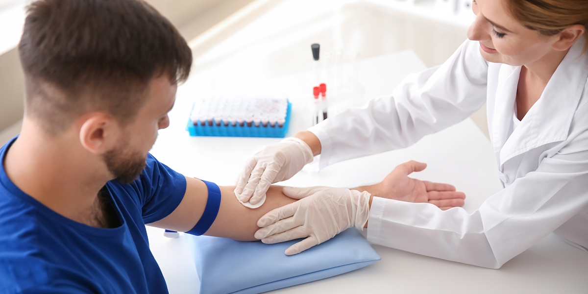 Female Medical Worker Prepping Male Patient Arm for Testing