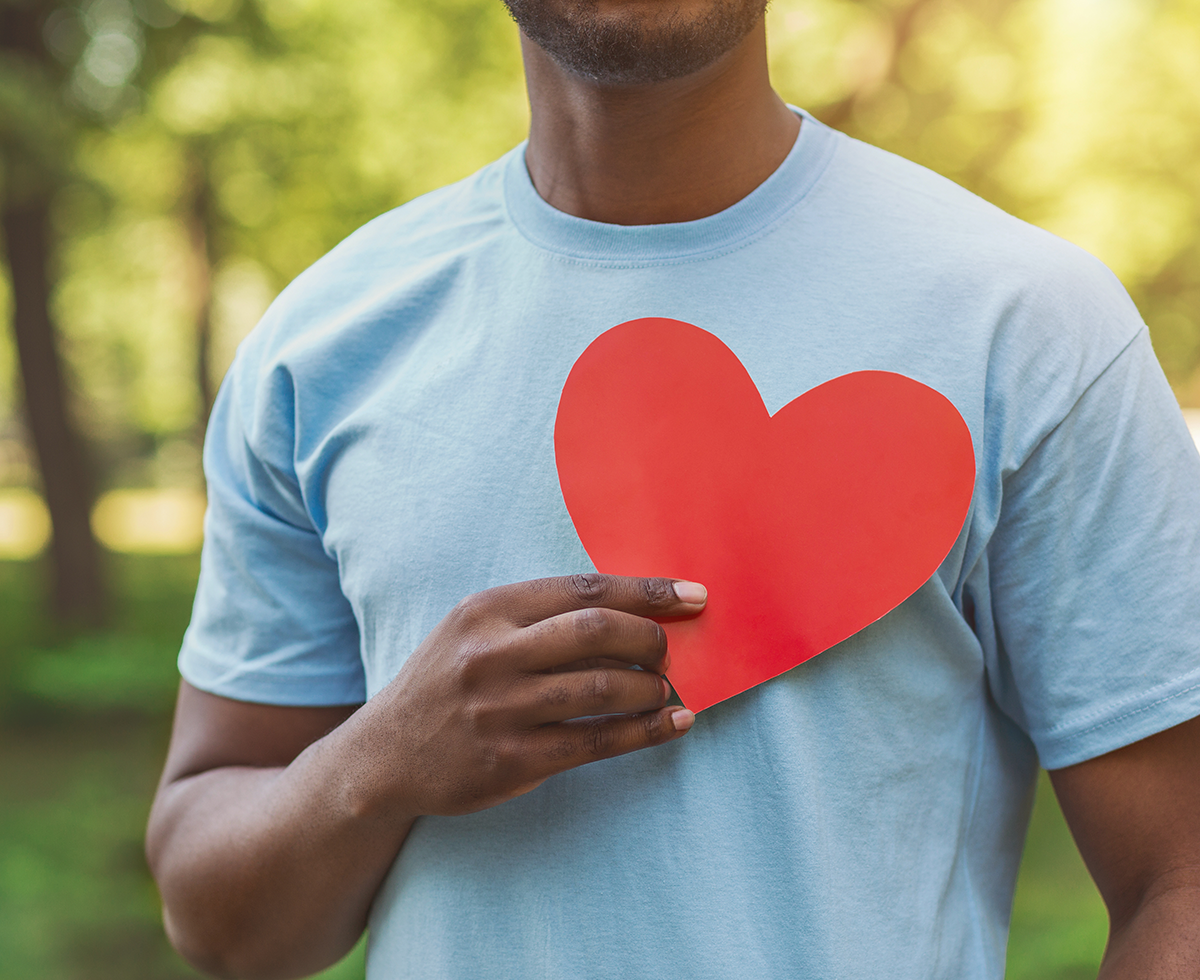 Black male holding red heart