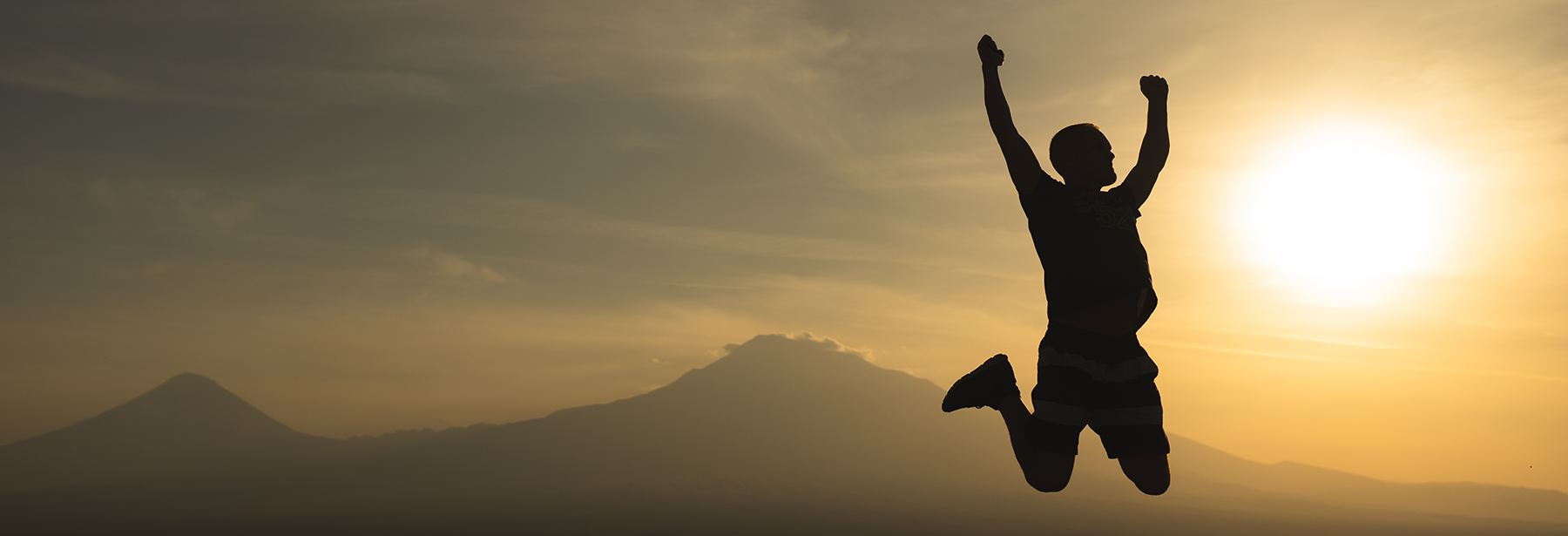 Silhouette of man jumping for joy