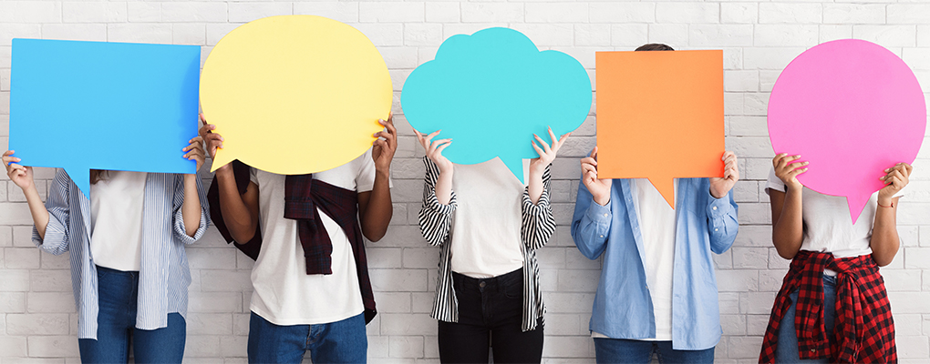 Image of group of people holding color speech bubbles