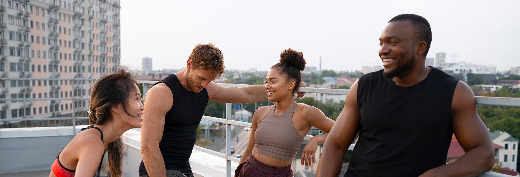 Two young females and two males on top of a building landing after a workout training.